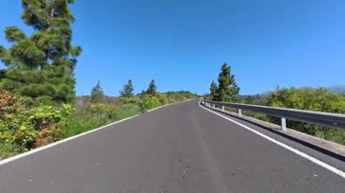 Güneşli bir günde açık mavi gökyüzünün altında zarif bir şekilde kıvrılan güzel bir yol.