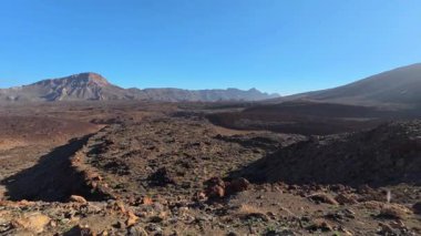 Göz kamaştırıcı ve büyüleyici bir panoramik manzara tepemizde canlı mavi bir gökyüzünün altında kurak volkanik araziler sergiliyor.