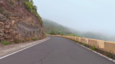 Şaşırtıcı derecede güzel, dolambaçlı bir yol sisli, gür, dağlık bir arazide zarifçe zikzak çiziyor.