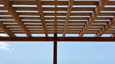 Sahil şeridinin sakin bir görüntüsü büyüleyici bir pergola tarafından çerçevelenmiş, nefes kesen güzellikler sergiliyor.