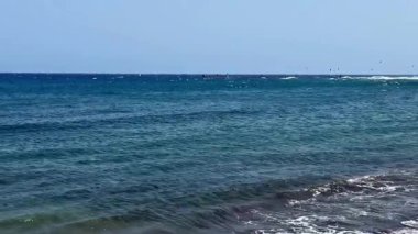 Manzaralı dalgaların, rüzgar sörfünün ve parlak mavi gökyüzünün olduğu okyanus sularının çarpıcı manzarasını deneyimleyin.