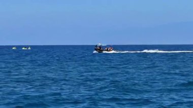 Gelin, güzel, berrak mavi gökyüzünün altındaki el değmemiş okyanus sularında jet ski yapmanın heyecanının tadını çıkarın.