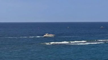 Göz kamaştırıcı lüks bir yat, berrak gökyüzünün altındaki güzel mavi okyanus dalgalarında zarifçe süzülüyor.