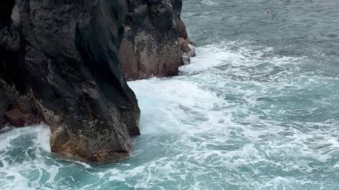 Güçlü okyanus dalgaları sert kayalara çarpar ve doğanın nefes kesici güzelliğini gözler önüne serer.