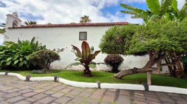 Tarihi bir arka planla tamamlanmış çeşitli canlı bitkilerin yer aldığı çok güzel sakin bir bahçe sahnesi.