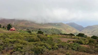 Parlak yeşillik ve doğal güzelliğin yer aldığı sisle kaplı yuvarlanan dağların nefes kesici manzarası..