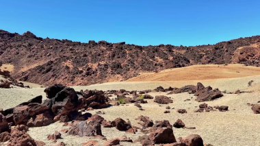 Berrak mavi gökyüzünün altında uzanan büyüleyici güzellikteki ve kayalık çöl manzaralarını keşfetmek için bir yolculuğa çıkın.