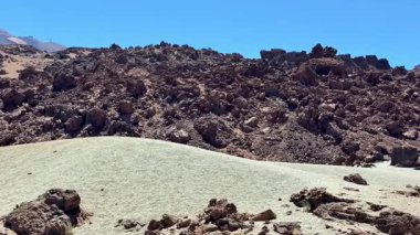 Bu nefes kesici bir manzara engin engebeli kayaları ve kumlu araziyi parlak mavi gökyüzünün altında gösteriyor.