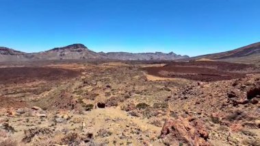 Engebeli dağlar ve canlı renklerin yer aldığı geniş bir volkanik arazinin nefes kesici ve çarpıcı manzarasına tanık olun.