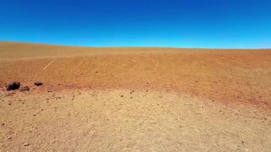Parlak mavi gökyüzünün altında uzanan çorak bir çöl manzarası kesinlikle nefes kesici ve nefes kesici.