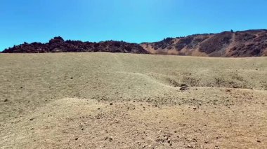 Çorak arazi, güçlü güneş ışığıyla aydınlatılan eşsiz jeolojik özelliklerin olağanüstü bir gösterisini sunar.