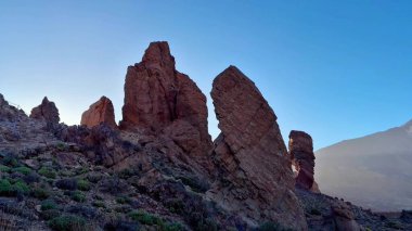 Benzersiz kaya oluşumlarının çarpıcı siluetleri şafak vakti berrak mavi gökyüzüne karşı görkemli bir şekilde duruyor.