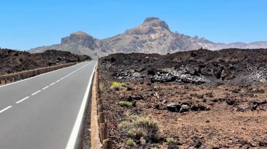 Berrak mavi gökyüzünün altındaki kendine özgü volkanik bir arazide güzel rüzgarlar estiren büyüleyici bir yol keşfet.