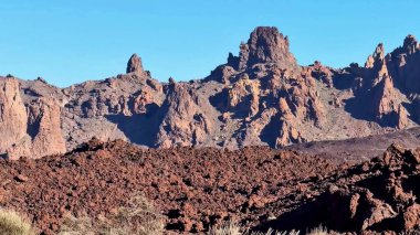 Güneşli, berrak bir gökyüzünün altındaki engebeli araziyle birlikte nefes kesici volkanik kayalıkları keşfedip keşfedin.