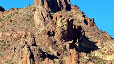 Nefes kesici manzara yukarıda parlak ve berrak bir mavi gökyüzüne karşı engebeli kaya oluşumlarını sergiliyor.