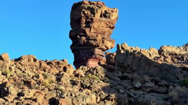 Sersemletici kaya oluşumu açık mavi gökyüzü tarafından vurgulandı, doğa ve manzara meraklıları için mükemmel..