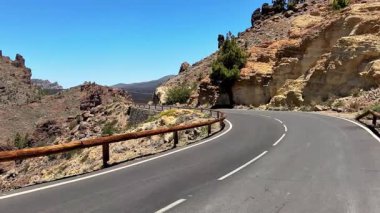 Güzel ve dolambaçlı bir yol kayalık kayalıkların ve yemyeşil bir dağ manzarasının içinden geçiyor.