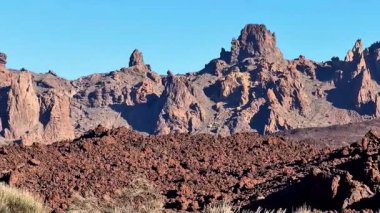 Güneşli, berrak bir gökyüzünün altındaki engebeli araziyle birlikte nefes kesici volkanik kayalıkları keşfedip keşfedin.