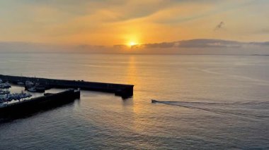 Huzurlu limanın üzerinde sakin bir gün batımı, doğanın nefes kesici güzelliğini gözler önüne seriyor ve kayıkla geziyor.