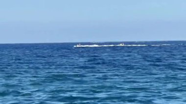 Okyanuslarda hızla ilerleyen, berrak mavi bir gökyüzünün altında ışıl ışıl parlayan bir su aracının heyacan verici görüntüsü.