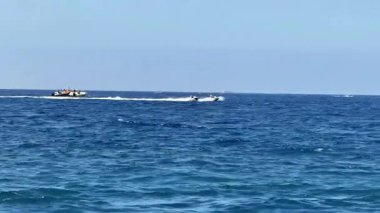 Heyecan verici jet ski yarışlarını canlı mavi okyanus sularında tecrübe edin. Yaz eğlencesi ve aktiviteleri için mükemmeldir.