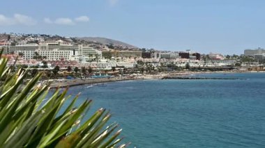 Kumlu plajları ve mavi sularıyla tanınan canlı bir sahil şehri güneşli bir gökyüzünün altında huzur içinde uzanıyor.