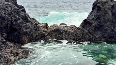 Dinamik okyanus dalgaları sert kaya oluşumlarına şiddetle çarparak gerçekten çarpıcı bir sahil manzarası yaratıyor.