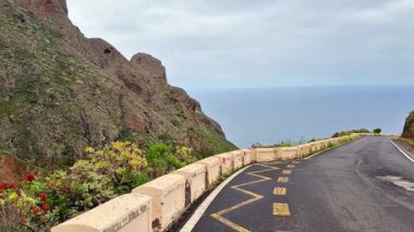 Canlı çiçeklerle kaplanmış, çarpıcı okyanus manzaraları ve dramatik uçurumlar sunan pitoresk bir sahil yolu..