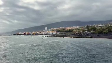 Huzurlu denizin yanında çarpıcı bir kıyı manzarası sergiliyor dramatik bir gökyüzüne karşı..