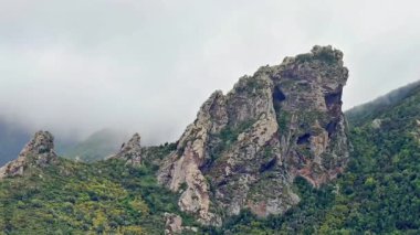 Nefes kesici bir manzara, yemyeşil ve ince bulutların sürüklediği görkemli dağları gösteriyor.