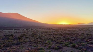 Güzel ve nefes kesici bir gün doğumu dingin ve resimli bir dağ manzarasında ılık renkler bırakır.