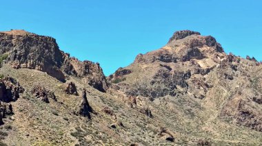 Güneşli bir atmosferde engebeli dağların nefes kesici ve çarpıcı manzarası ve güzel manzarası.
