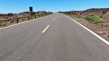 Nefes kesen manzaralı bir manzara, engebeli ve güzel bir gökyüzünün altında kıvrılan boş bir yolu yakalar.