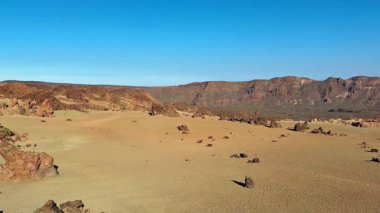 Nefes kesici bir çöl manzarası eşsiz ve çarpıcı kaya oluşumlarını sergiliyor canlı, mavi gökyüzüne karşı.