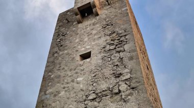 Görkemli bir taş yapı bulutlu güzel bir gökyüzüne karşı yükseliyor, göz kamaştırıcı antik mimariyi sergiliyor.