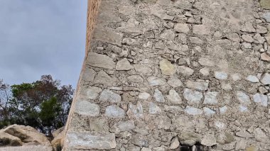 Dramatik ve resimli gökyüzüne karşı kurulmuş antik bir taş kuleye nefes kesici ve çarpıcı bir manzara.