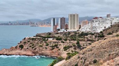 Çarpıcı bir kıyı manzarası Benidorms 'un dramatik bir gökyüzü ve kayalık bir kıyı şeridine karşı ufuk çizgisini gösteriyor. Unutulmaz.