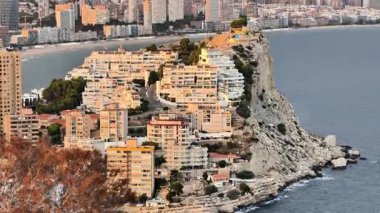 Çağdaş mimarinin çarpıcı manzarası. Kıyıdaki kayalıklar ve sakin sular üzerinde çarpıcı binalar.