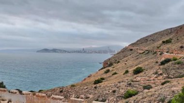 Benidorm siluetinin nefes kesici manzarası güzel bulutlu gökyüzüne karşı kurulmuş, kıyı mutluluğunu gözler önüne seriyor.