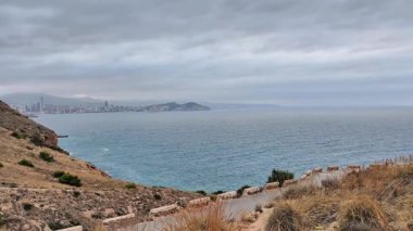 Bulutlu bir günde çekilen Benidorm 'un çarpıcı kıyı manzarası sakin denizi ve manzarayı gözler önüne seriyor..