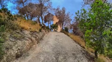 Davetkar bir yol çarpıcı bir kuleye götürür, bereketli doğayla çevrili ve nefes kesici manzaralar sunar.