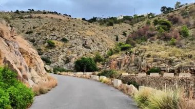 Bu büyüleyici video, serin bir vadi boyunca serinletici kayalık oluşumlar ve yemyeşil çimlerle dolambaçlı bir yolculuk sergiliyor.