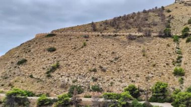 Okyanus manzaralı bir tepeye çıkan toprak bir yolda huzurlu bir yolculuk. Video, sakin atmosferi ve bereketli çevreyi vurguluyor.