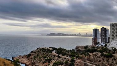 Bir sahil kentini uçurumun kenarından güzelliğini yakalar. Bu video, engebeli kayalıkları kentsel yaşamla harmanlayarak, bulutların içine gizlenmiş okyanus manzaralarını gösteriyor.