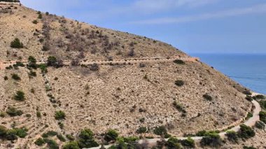 Dolambaçlı bir yol boyunca bir hava yolculuğu okyanus kıyısındaki bir tepeye yükselir. Mavi suların ve yemyeşil yemyeşil, gezgin şehvetin kontrastını gözler önüne serer.