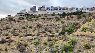 Güzel bir video, yemyeşil ağaçların arasında manzaralı bir tepede çarpıcı binaları ön plana çıkarıyor. Büyük yapı nefes kesici manzaralar sunuyor, sükunet ve çekiciliği somutlaştırıyor.