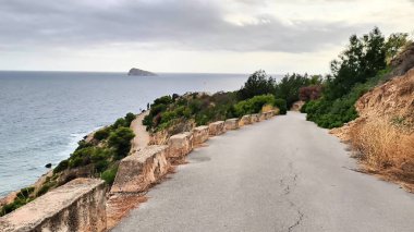 Dolambaçlı bir yol boyunca sakin bir yolculuk okyanusa götürür. Uçsuz bucaksız denize inen tepeleri olan sakin manzaraları yakalar. Huzurlu bir kaçışı davet eder.