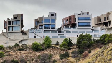 Bu video modern evlerle dolu, görsel ahenk ve çarpıcı manzaralar yaratan, doğayla zıt mimari yapıya sahip pitoresk bir yamaçtan oluşuyor.