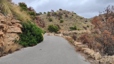 Dolambaçlı bir yol boyunca nefes kesen bir yolculuk yüksekteki dağların arasında manzaralı bir tepeye tırmanıyor, sükuneti ve keşfi davet ediyor.