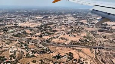 Bir uçak penceresinden kentsel manzaraların nefes kesici hava manzarası. Bu büyüleyici görüntüler canlı şehir yaşamını ve mimarisini gösteriyor.